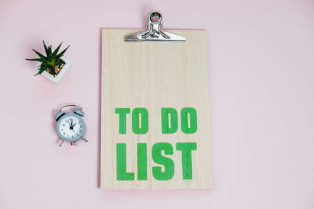 To Do List alarm clock and plant on a pink background Top View Flat Layの写真素材