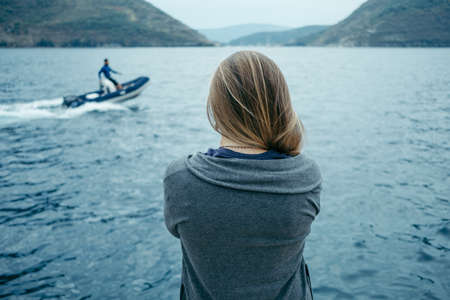 Back view of woman thinking alone and watching the sea  with the horizon in the background, Montenegroの写真素材