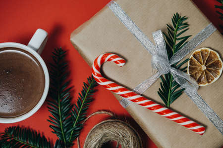 Hot chocolate, gift, candy canes on red board. Holiday backgroundの写真素材