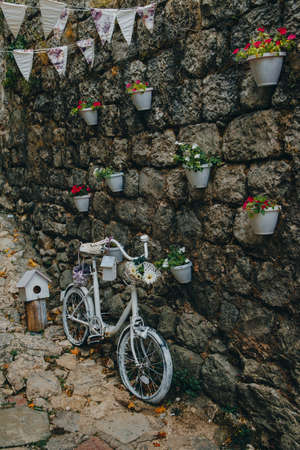 Bicycle decorated with flowers near the wallの写真素材