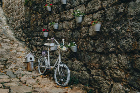 Bicycle decorated with flowers near the wallの写真素材