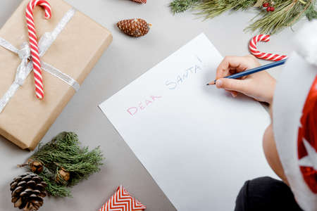 Letter for Santa. Boy Hands on paper, gifts and marshmallows. Top view, flat layの写真素材