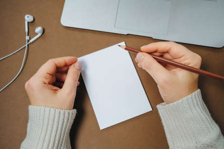 Brown Office desk of Business workplace. Woman hands with pencil and notepad, laptop, spectacles and coffee cup. Top view. Flat layの写真素材