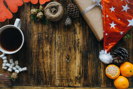 Christmas background with santa hat, Coffee with marshmallows and gifts on wooden table. Top view, flat layの写真素材