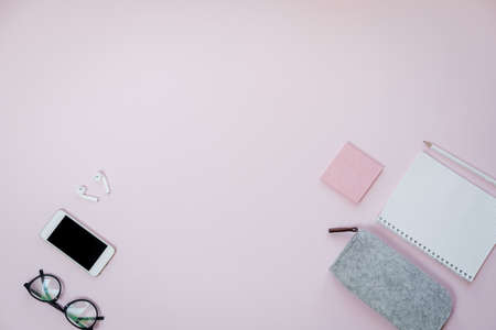 Phone and stationery on pink table. Business concept. Top view, flat layの写真素材