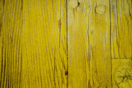 Old wooden board with yellow paint, texture.の写真素材