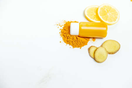 Ginger shot healthy drink with curd in a plastic bottle on white background. Immunity Boosting Tonic. Top viewの写真素材