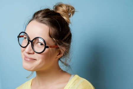 Nerd young woman on a blue background. Studio shotの写真素材