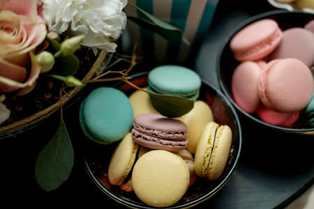 Sweet table at the feast. Flowers and multi-colored macaroonsの写真素材