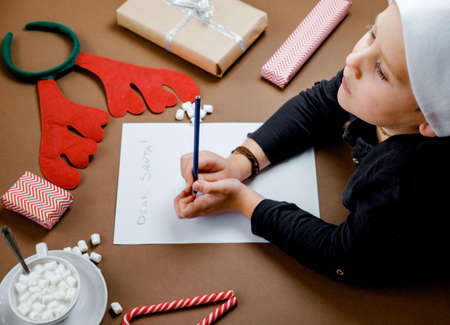 Letter for Santa. Boy Hands on paper, gifts and marshmallowsの写真素材