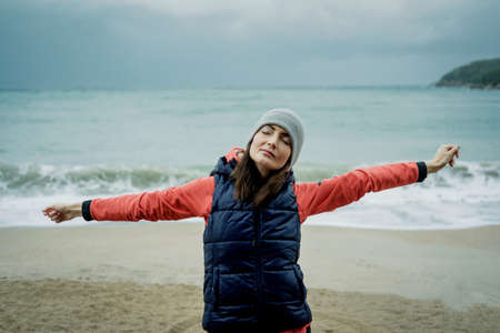 Young woman wearing a sports vest exercising by winter sea の写真素材