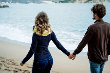 Young couple walking along the sea in autumn, Montenegro. unfocused photoの写真素材