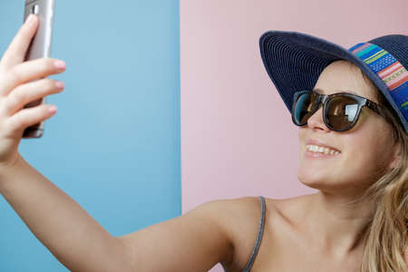 Pretty Young woman in hat and sunglasses with phone. Summer conceptのeditorial素材