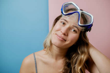 Pretty young woman in diving mask against pink background. Summer conceptのeditorial素材