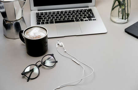 Work space table with laptop, phone and coffee on grey background. Top view, Flat lay