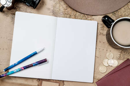Flat lay adventure vintage background with hat, camera and passport on old map. Top viewの写真素材