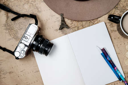 Flat lay adventure vintage background with hat, camera and passport on old map. Top viewの写真素材