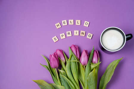 Cup of coffee and Purple tulips on a violet background and wooden letters. Spring concept. Top view, flat lay, copy spaceの写真素材