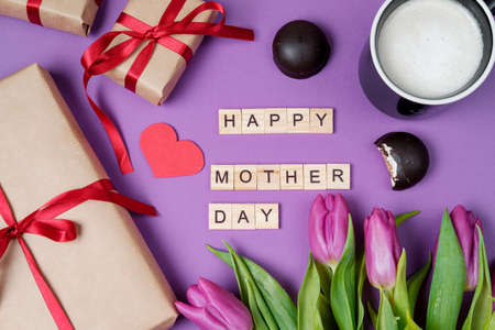 Bouquet of purple tulips, gift box and wood letters on violet background. Mother day. Flat lay, top viewの写真素材