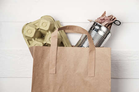 Separate garbage collection: paper bag, egg packing and aluminum can. Eco concept. Flat lay