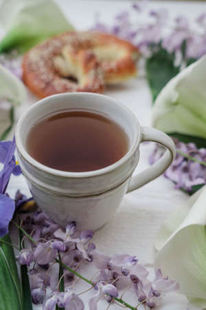 Herbal tea with wisteria, irises, white callas on gray background. の写真素材