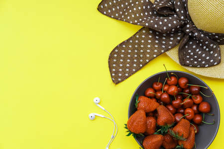 Summer background on the yellow table: Straw Hat, soda, berries. Top view, flat lay