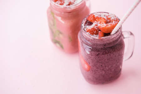 Berry smoothies with strawberries and blueberries in a glass jar on a gray backgroundの写真素材