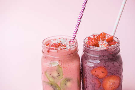 Berry smoothies with strawberries and blueberries in a glass jar on a gray backgroundの写真素材