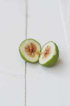 Green sliced figs on white table. Space for textの写真素材