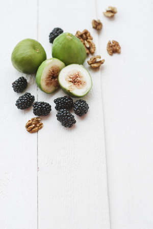Salad with arugula figs blackberry and walnut on white table. Top view, space for textの写真素材