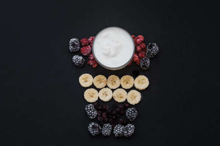 Ingredients for smoothies. Flat lay Composition with raspberries and bananas on a black background. Top viewの写真素材
