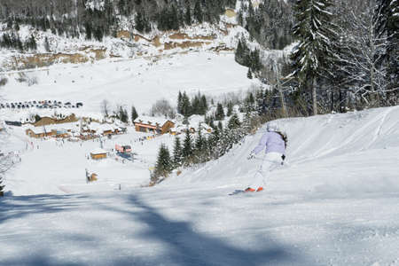 Skier skiing in fresh snow on ski in the mountains on a sunny winter day in Montenegroの写真素材