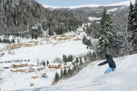 Skier skiing in fresh snow on ski in the mountains on a sunny winter day in Montenegroの写真素材