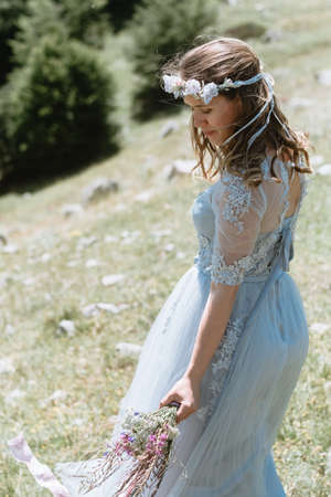 Bride in a dress walking along the road against the background of the mountains.の写真素材