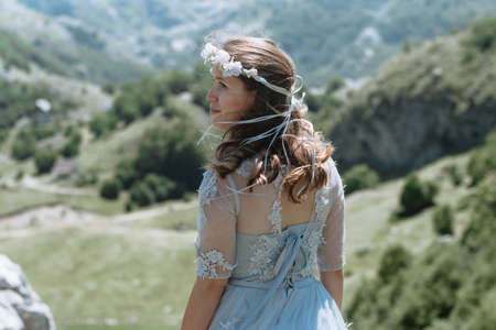 Bride in a dress walking along the road against the background of the mountains.の写真素材