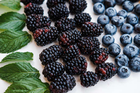Top view of healthy berries in rainbow colours, pineapple, blackberries, blueberries and raspberries...