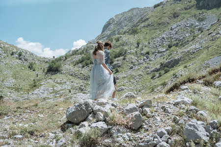 Romantic  couple walking along the road against the background of the mountains. Slow motionの写真素材