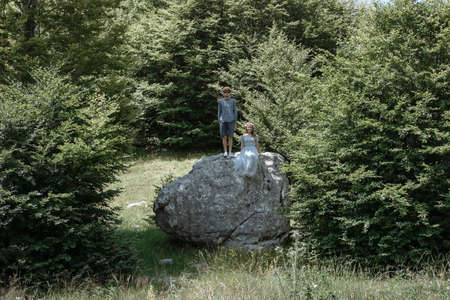 Stylish Romantic  couple on the big rock against the forestの写真素材