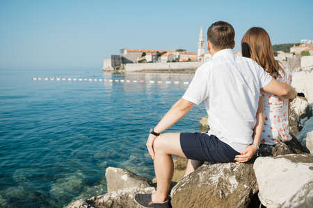 Back view of romantic couple at the beach and looking to the horizon.の写真素材