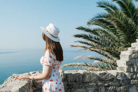 Back view of a young beautiful woman with hat  looking to the horizon.の写真素材