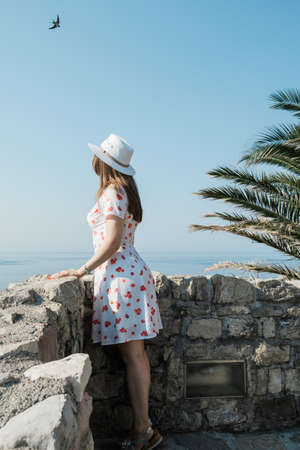 Back view of a young beautiful woman with hat  looking to the horizon.の写真素材
