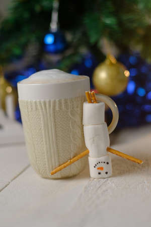 Marshmallow snowman and cocoa on the background of Christmas lightsの写真素材