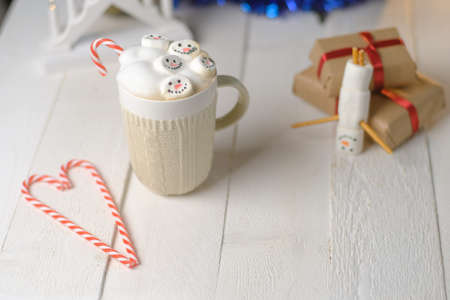 Marshmallow snowman and cocoa on the background of Christmas lightsの写真素材