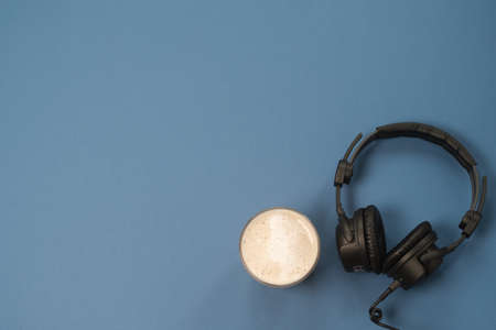 Flat lay composition with Headphones, microphone and coffee on a blue background. Podcast or webinar concept.の写真素材