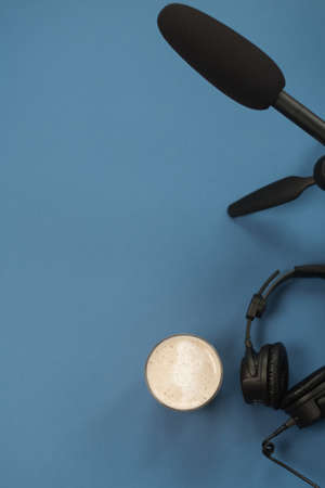 Flat lay composition with Headphones, microphone and coffee on a blue background. Podcast or webinar concept.の写真素材