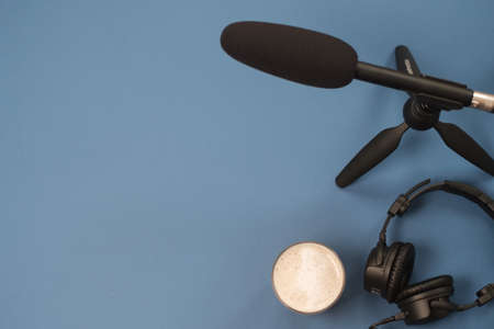 Flat lay composition with Headphones, microphone and coffee on a blue background. Podcast or webinar concept.の写真素材