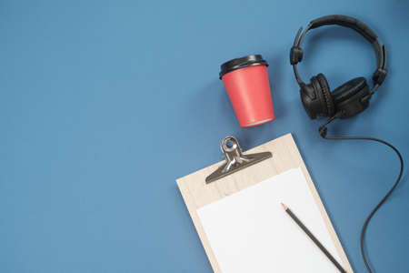 Flat lay composition with Headphones, microphone and coffee on a blue background. Podcast or webinar concept.の写真素材