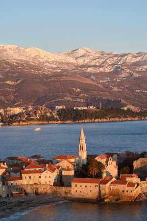 View of Budva, the old town in Montenegro at sunset and snow-capped mountains