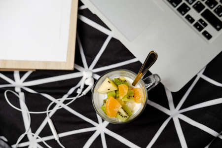 Morning in pastels: fruit breakfast and laptop on a black bedの写真素材