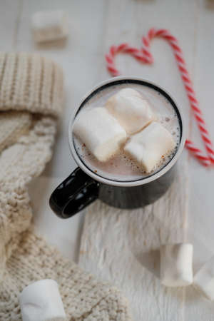 Top view of Cocoa with marshmallows and chocolate on a background of Christmas lightsの写真素材